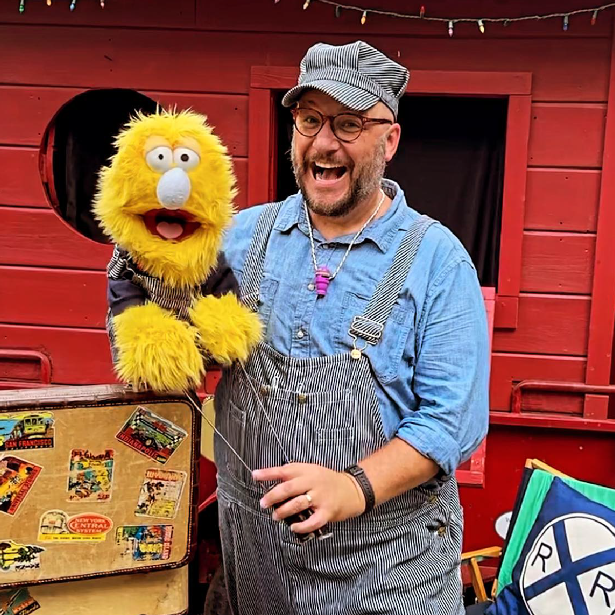 Man holding a yellow puppet