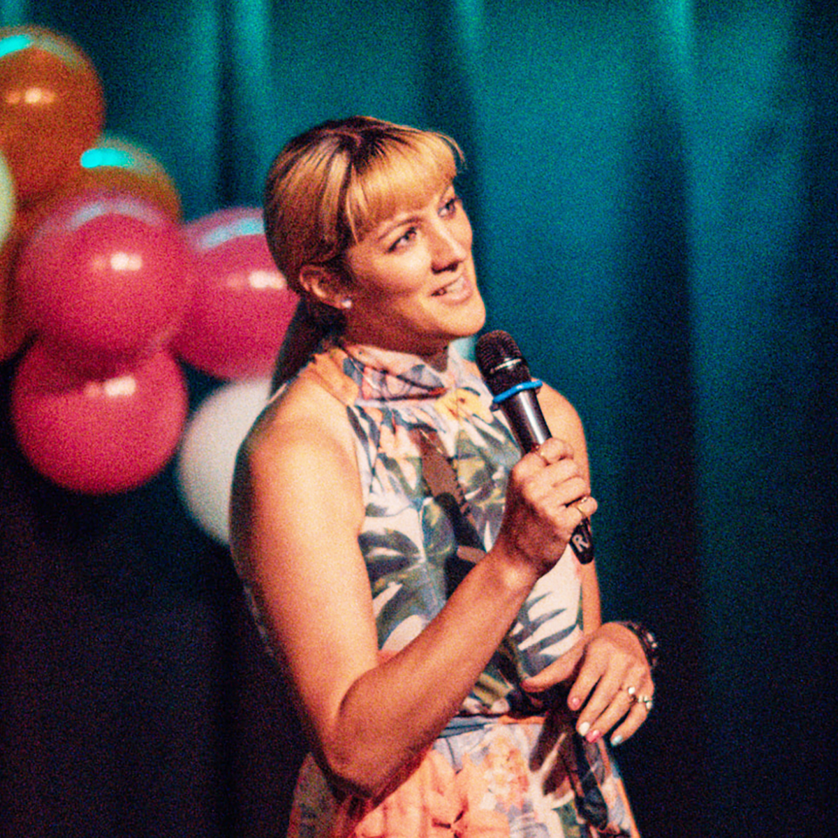 Photo of Ms. Adventure on stage with a microphone