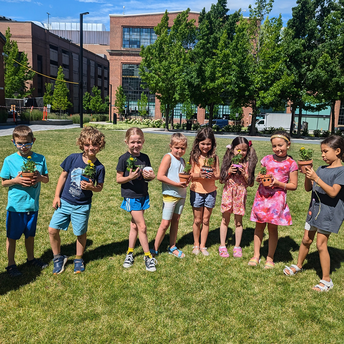 youth students outside holding potted flowers