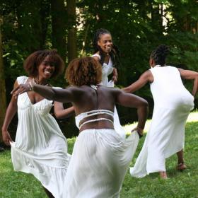 4 dancers outside on green grass