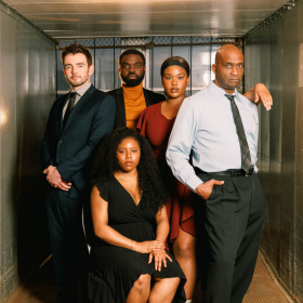 A Raisin in the Sun cast posed in business attire looking straight ahead