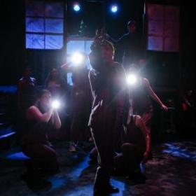 photo of dancers in shadow with flashlights