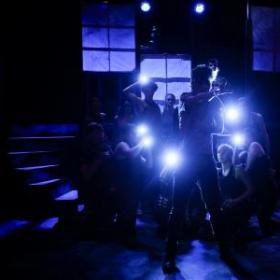 photo of dancers in shadow with flashlights