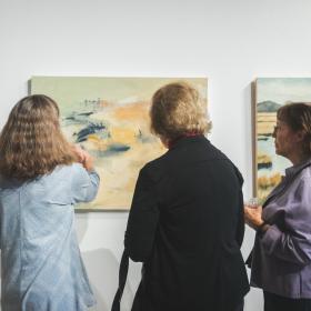 Opening reception photo of people looking at art